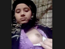 A young Indian woman reveals her petite breasts and intimate area