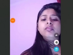 A young woman flaunts her breasts in a seductive manner